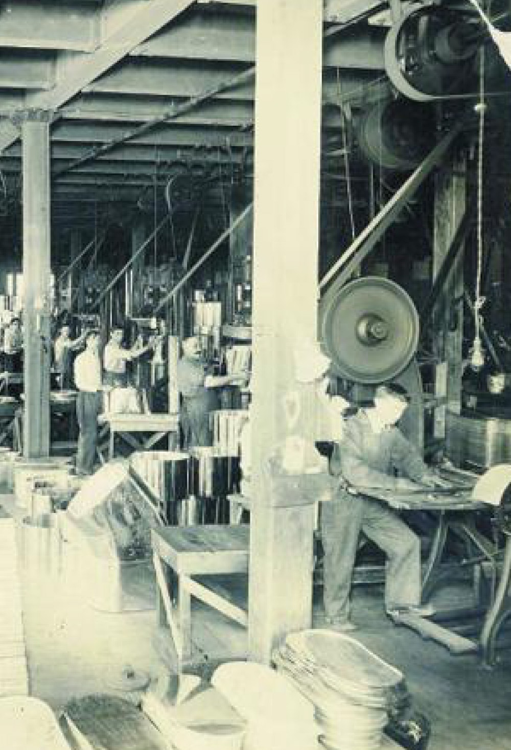 Historic factory interior with workers and manufacturing equipment